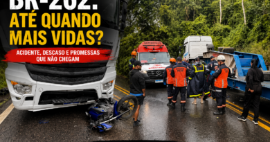 Acidente na BR-262 em trecho de serra com pista molhada. A imagem mostra uma carreta parada após colisão com uma motocicleta caída à frente do veículo, enquanto equipes do Corpo de Bombeiros e do Samu atendem a ocorrência. Ao fundo, a vegetação típica das Montanhas Capixabas reforça o cenário da rodovia. Sobre a foto, o título destaca o debate sobre segurança viária e as promessas não cumpridas para a BR-262.